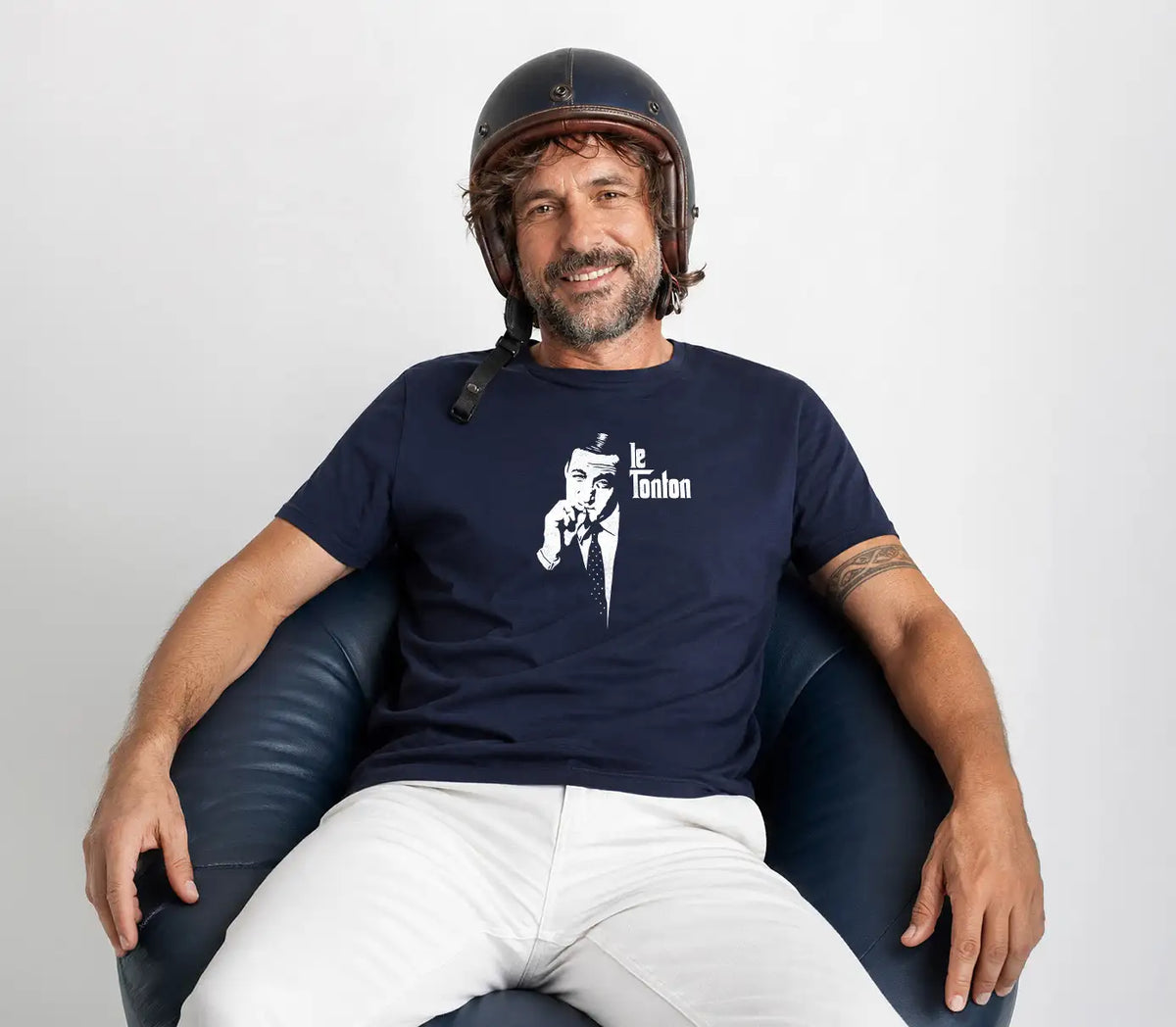 Bannière Rueduteeshirt - homme assis dans un fauteuil portant un t-shirt bleu marine de qualité.